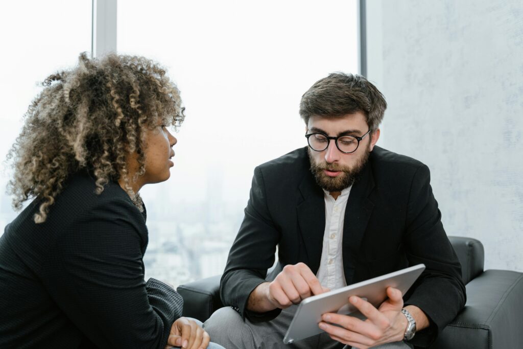 A marketing professional engaging in a face-to-face conversation with a client in a modern business setting.